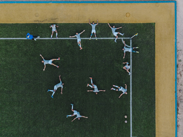 Players warming up on an artificial turf pitch.